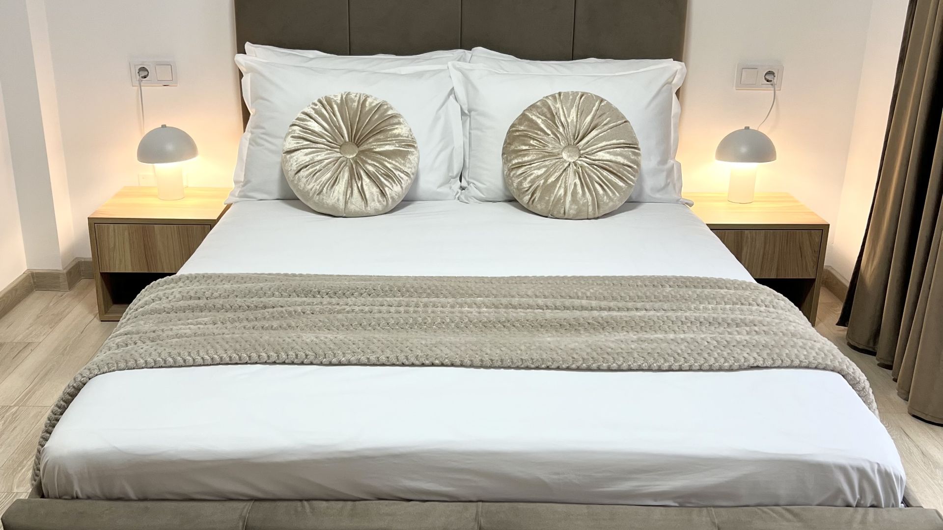 A calm double bedroom with warm bedside lamps