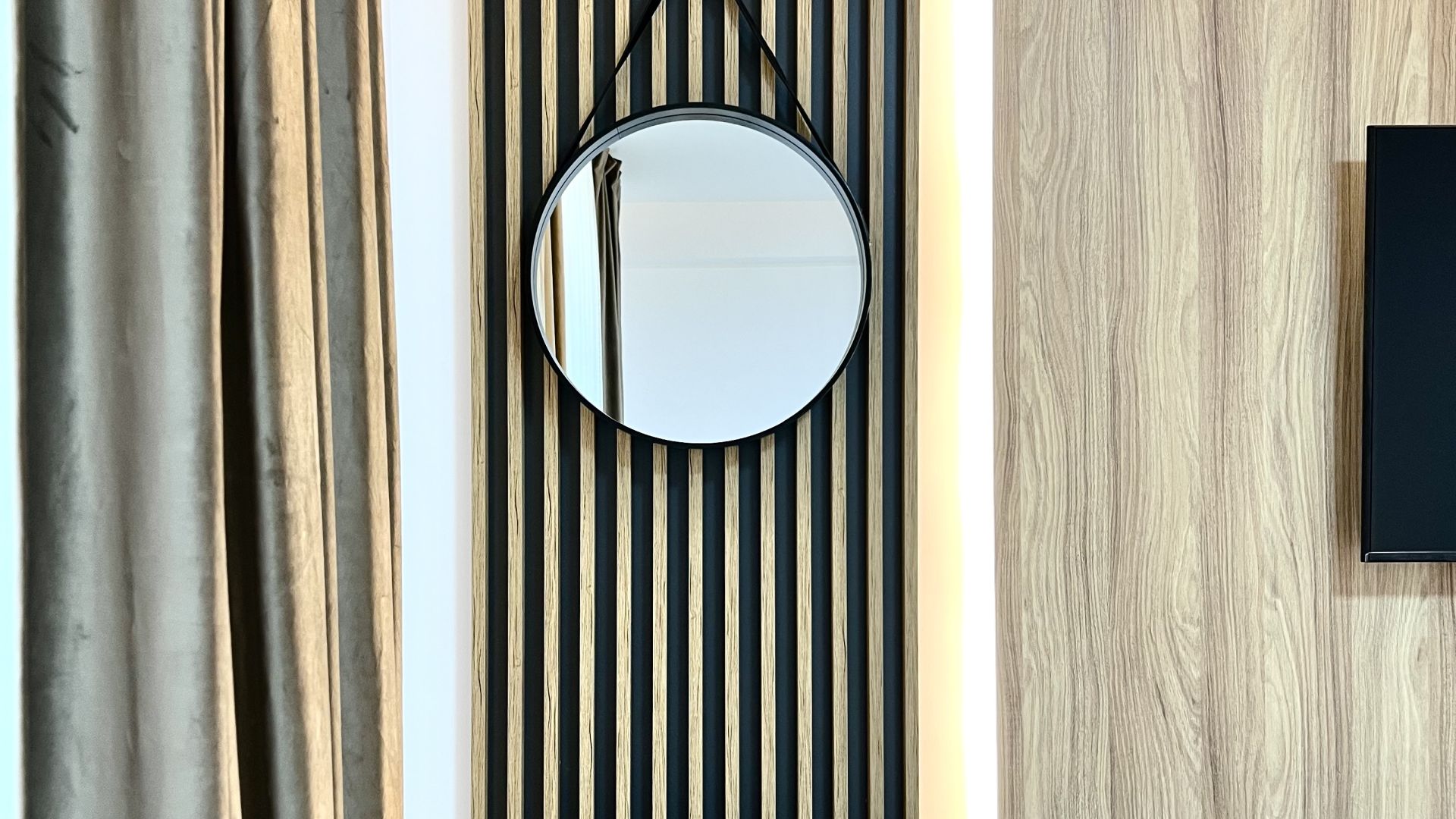 Honey-oak feature wall lit by warm cove lighting